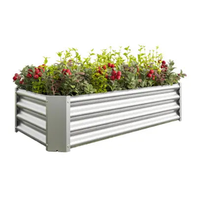 Lecho elevado de jardín de metal de 4x2x1 pies, maceta galvanizada plateada, fabricado en metal corrugado plateado, relleno con follaje verde y flores rojas.