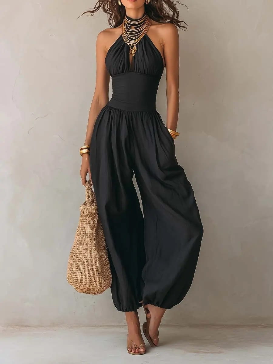 Mono tipo halter de pierna ancha en color negro con cuerpo ceñido y pantalones de pierna ancha con caída fluida en tejido negro.