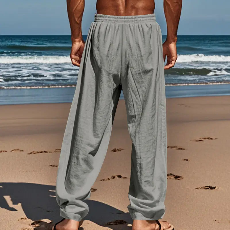 Gray loose-fitting men’s linen joggers with an elastic waistband and cuffed hems designed for casual wear.