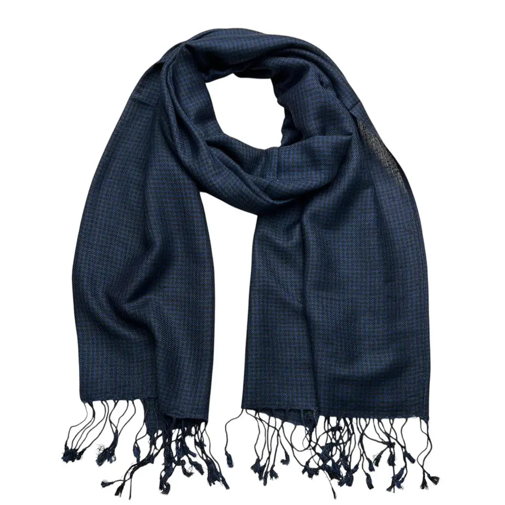 Une écharpe en sergé jacquard à chevrons marine, en tissu tissé de couleur bleu marine, avec des pompons noirs aux extrémités.