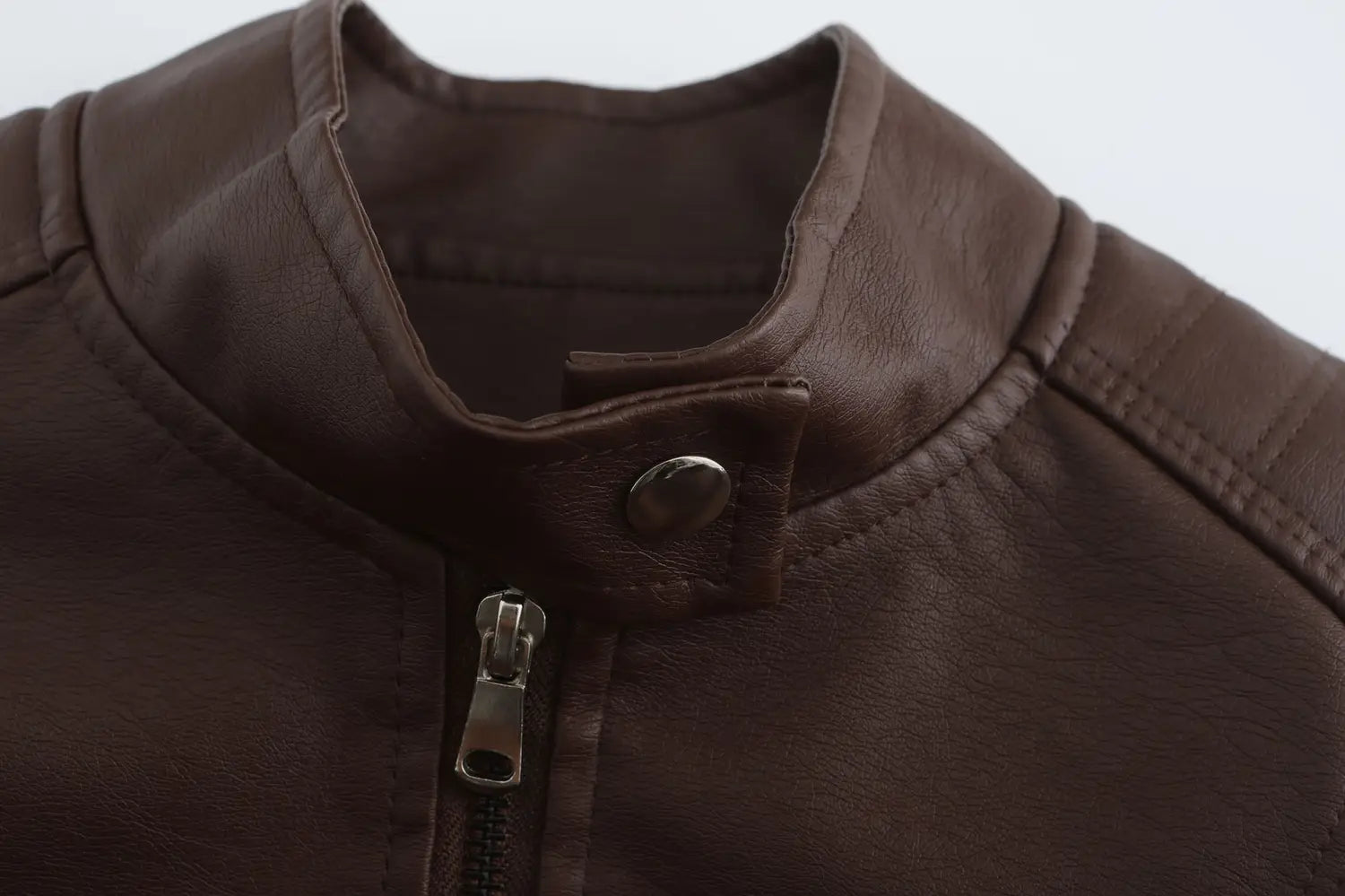 Veste motard en faux cuir marron avec col à boutons-pression et fermeture éclair argentée, sur un produit de veste motard en faux cuir avec col montant
