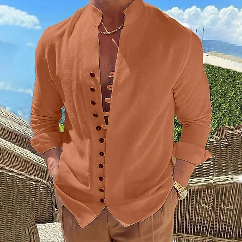 A man wearing a rust-colored mandarin collar linen blend wrinkle resistant casual shirt with long sleeves and dark buttons.