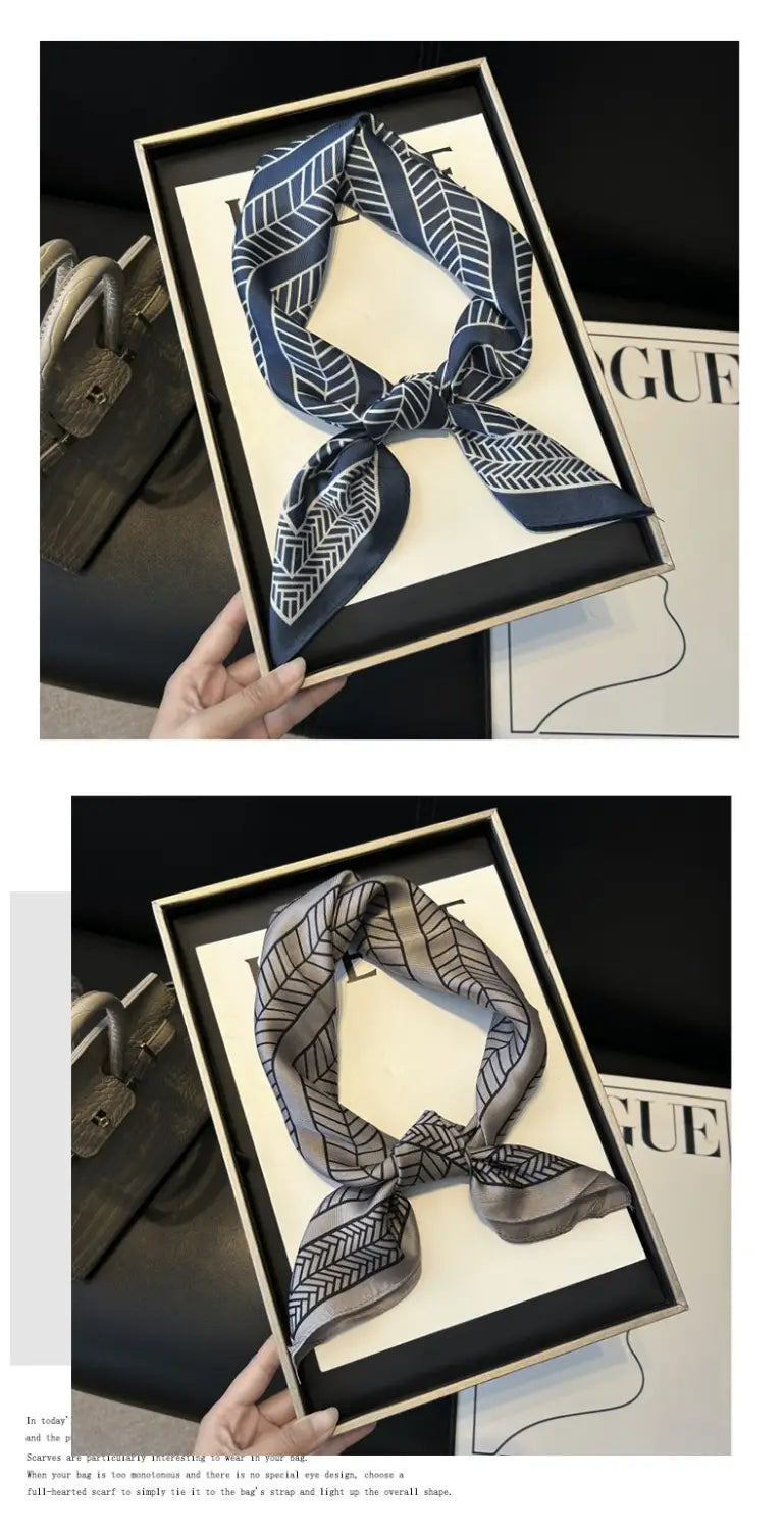 A navy blue and white geometric patterned twill silk look square scarf displayed in a gift box.