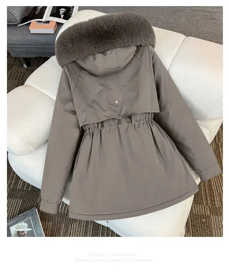 Parka matelassée à capuche avec col de fourrure gris, au col de fourrure marron foncé duveteux et à la taille resserrée.