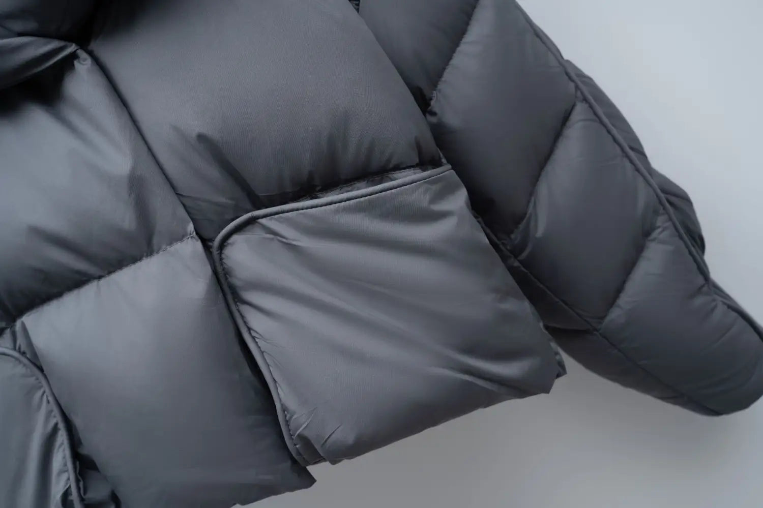 Dark gray quilted down jacket patchwork with large lapel in Korean style featuring smooth water-resistant fabric and stitched paneling.