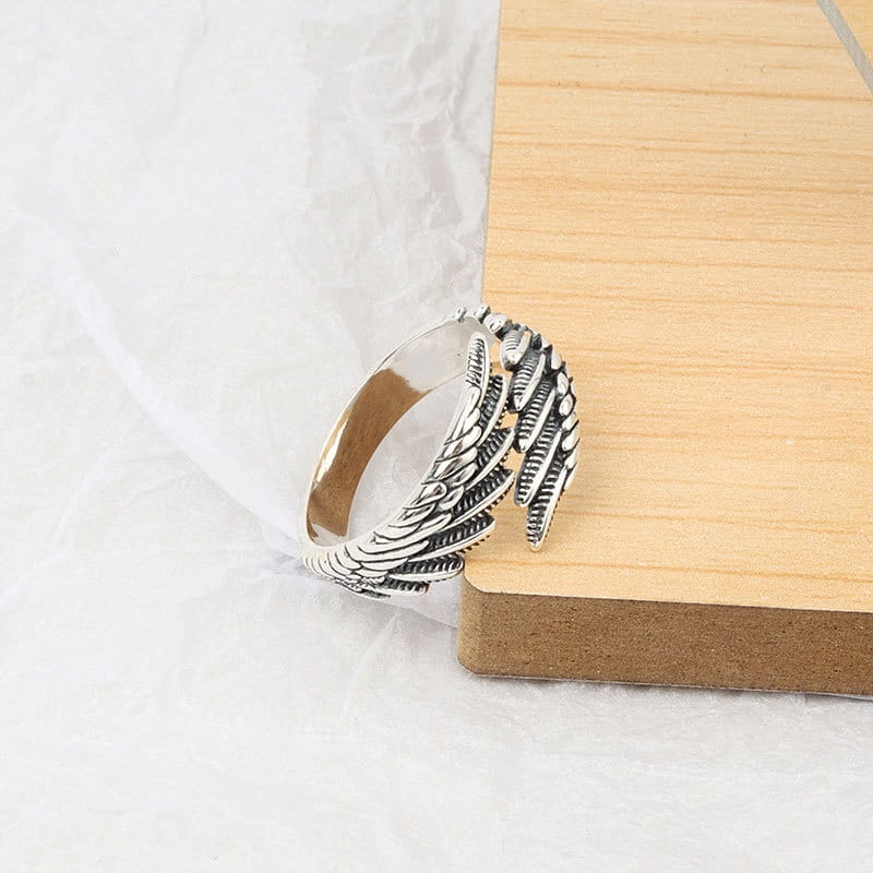 925 sterling silver detailed angel wing ring in polished metallic finish with intricate feather detailing.