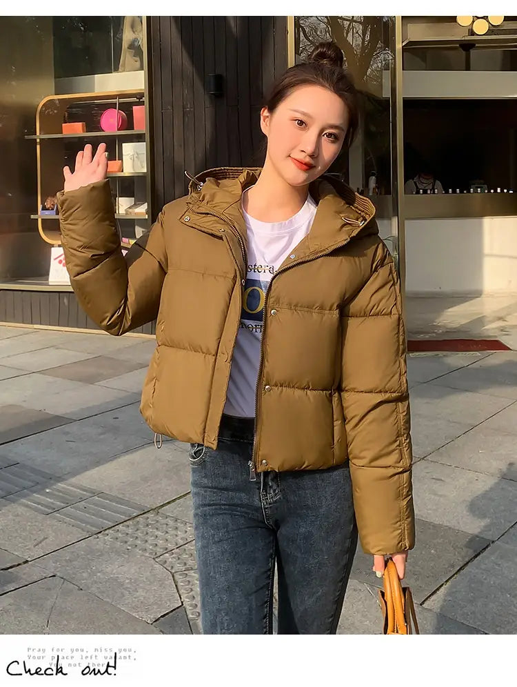 A stylish olive green women hooded short down jacket with a quilted design and a hood for warmth.
