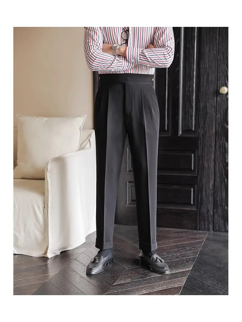 Men’s tailored pleated black wool trousers with a straight leg fit and rolled cuffs.