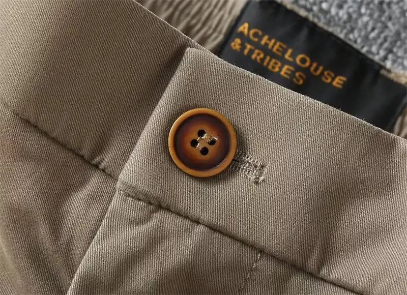 A warm circular wooden button with four holes on beige fabric of men casual slim fit khaki cargo shorts.
