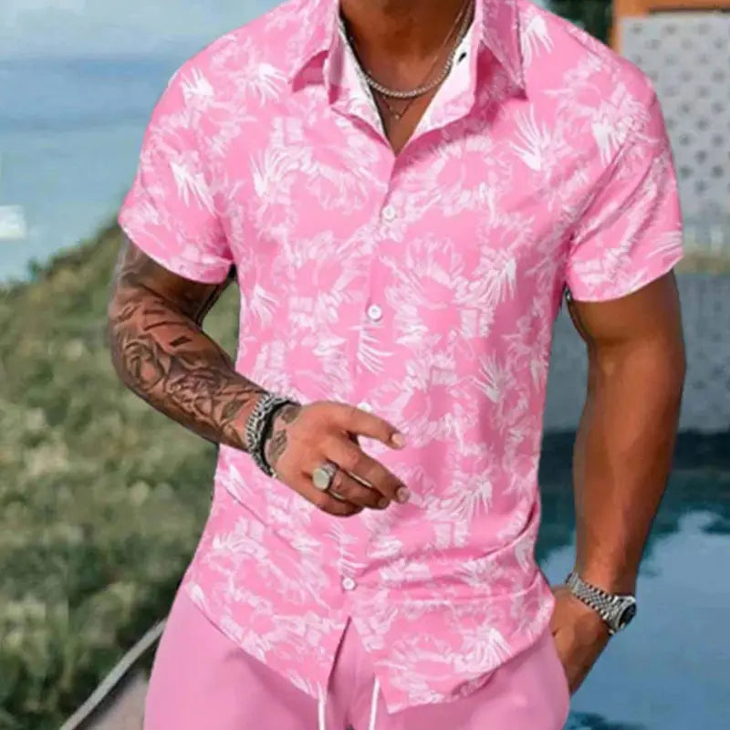 Men’s tropical print short sleeve shirt and shorts set featuring a pink short-sleeved button-up shirt with a white tropical leaf pattern.