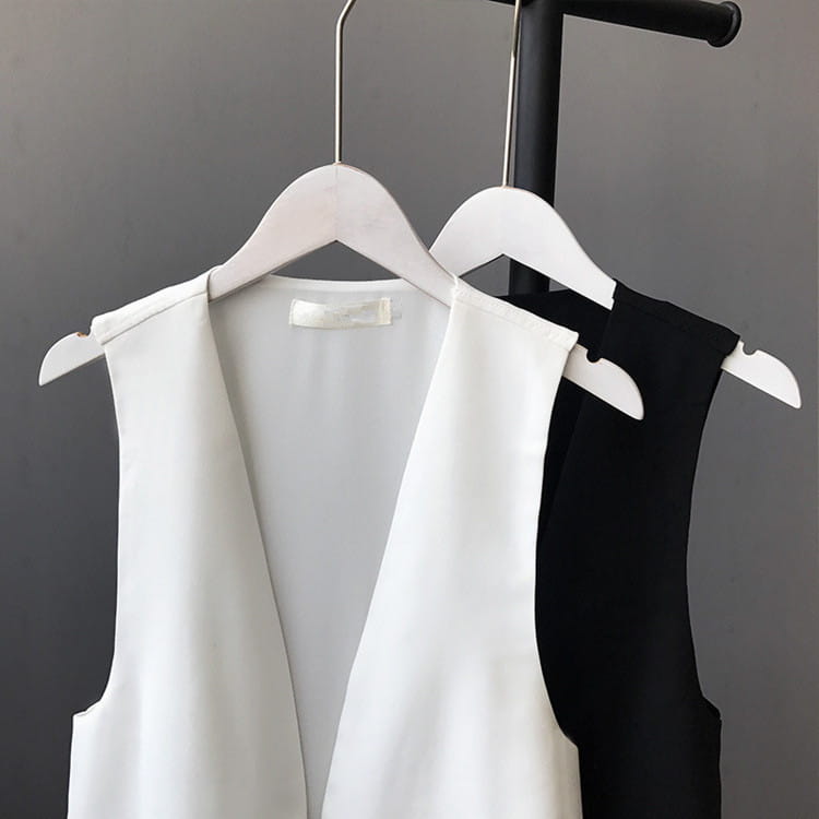 Weißer Satin-Chiffon-Lagenrock mit asymmetrischer Passform und tiefem V-Ausschnitt, auf einen Holzbügel gehängt.