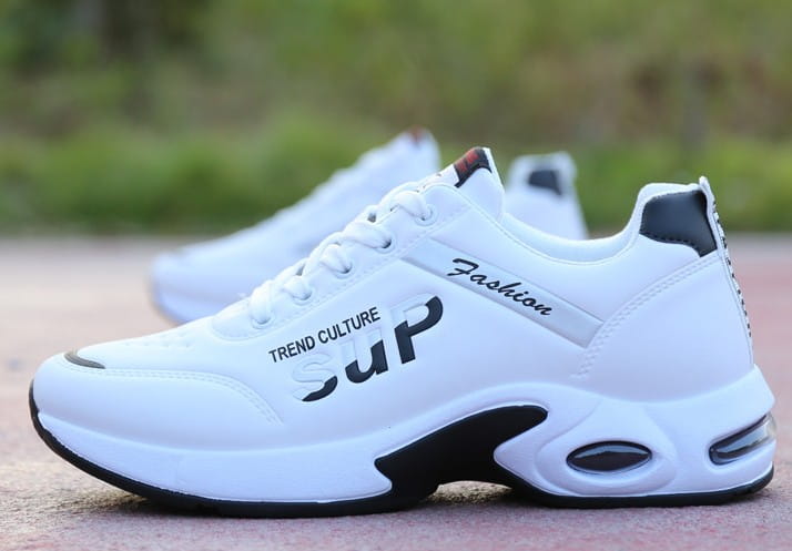 Men’s casual sportswear leather running shoes in white and black with a chunky sole featuring trend culture and fashion text on the side.