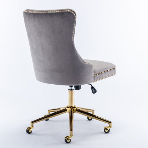 Chaise de bureau en velours capitonné gris avec piètement pivotant en métal à finition ton sur ton or et garniture à clous décoratifs.