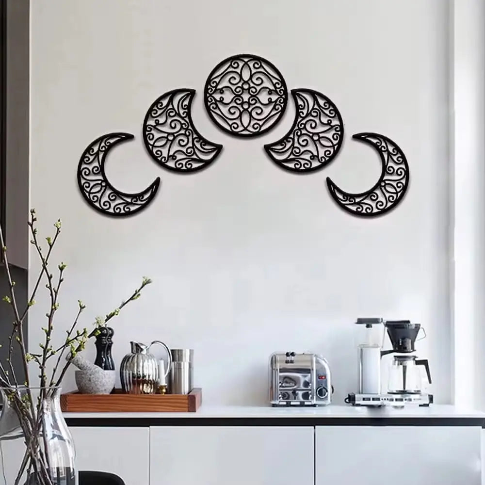 Black metal wall art featuring an intricate ornate design of the five phases of the moon in a five piece moon phase wall art black metal decor.