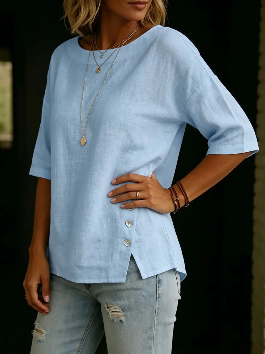 Light blue linen casual top with three-quarter sleeves and asymmetrical button-front detail.