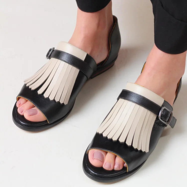 women’s tassel leather beach sandals in black and cream featuring a fringed strap design in leather