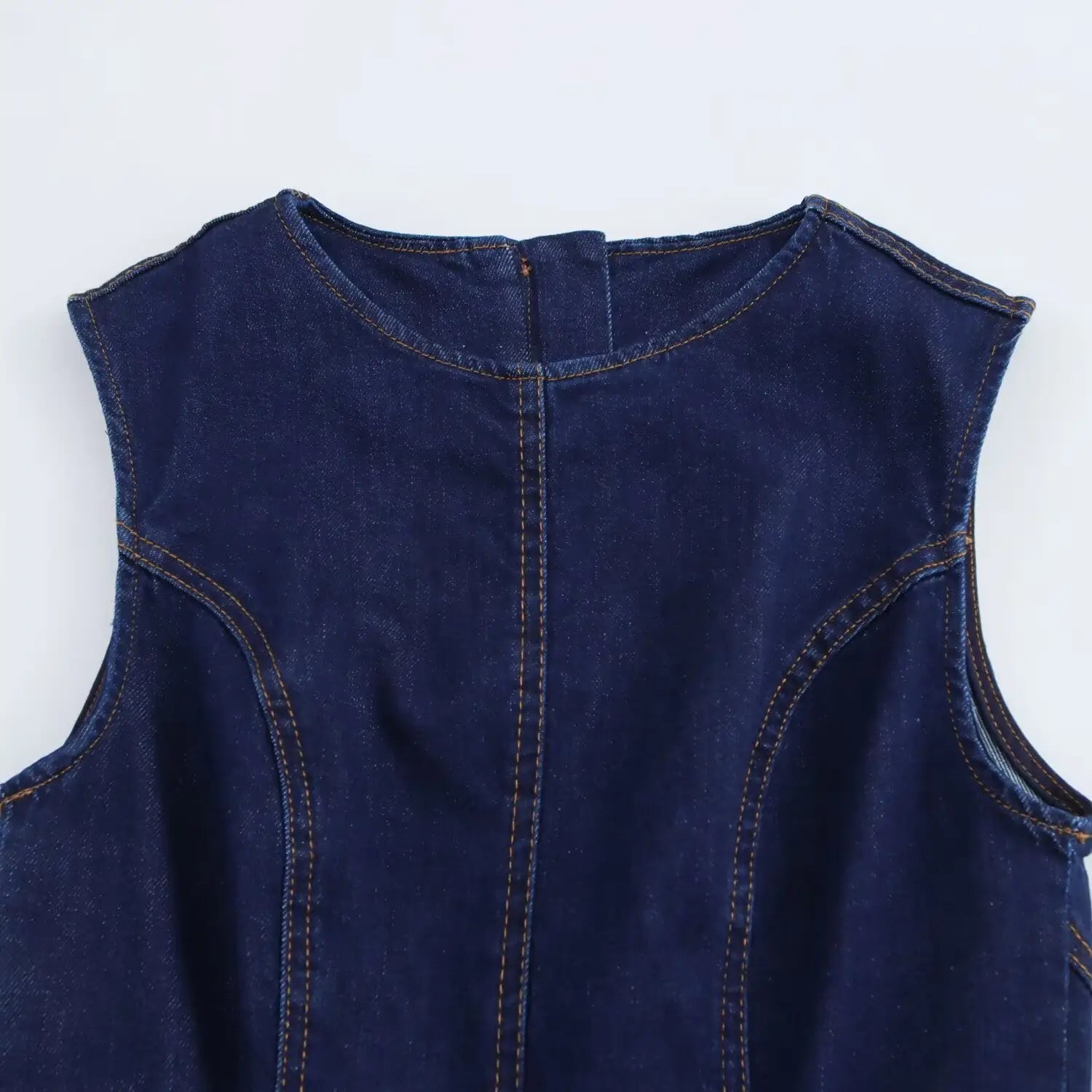 Navy crew neck sleeveless denim a-line dress featuring a dark blue denim sleeveless top with a rounded neckline and visible stitching.