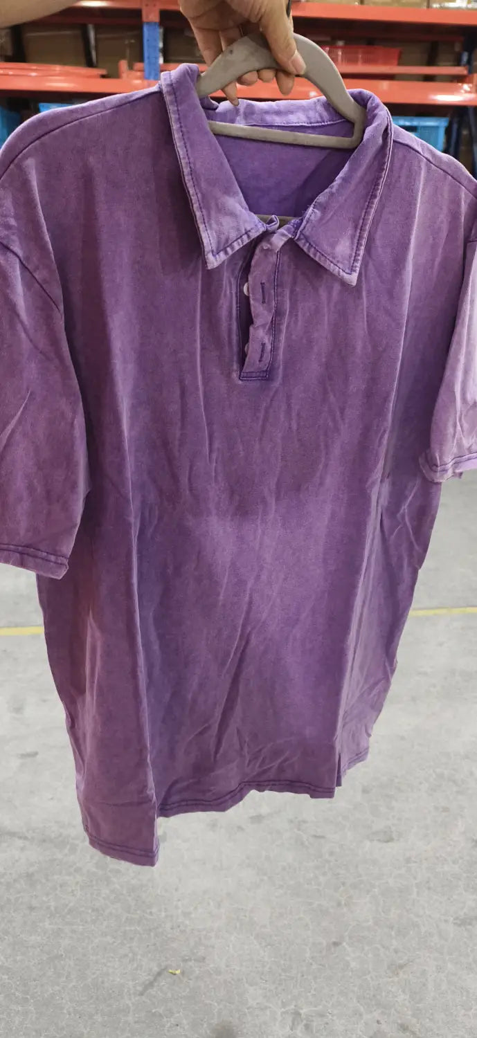 Ein weiches, verblasstes violettes ausgefranstes Baumwoll-Poloshirt mit kurzen Ärmeln, einem klassischem Kragen und einer Knopfleiste.