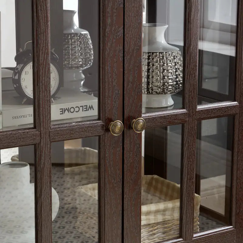 led curio display cabinet with adjustable shelves in dark wood frame featuring glass doors with brass knobs and grid-patterned panes.