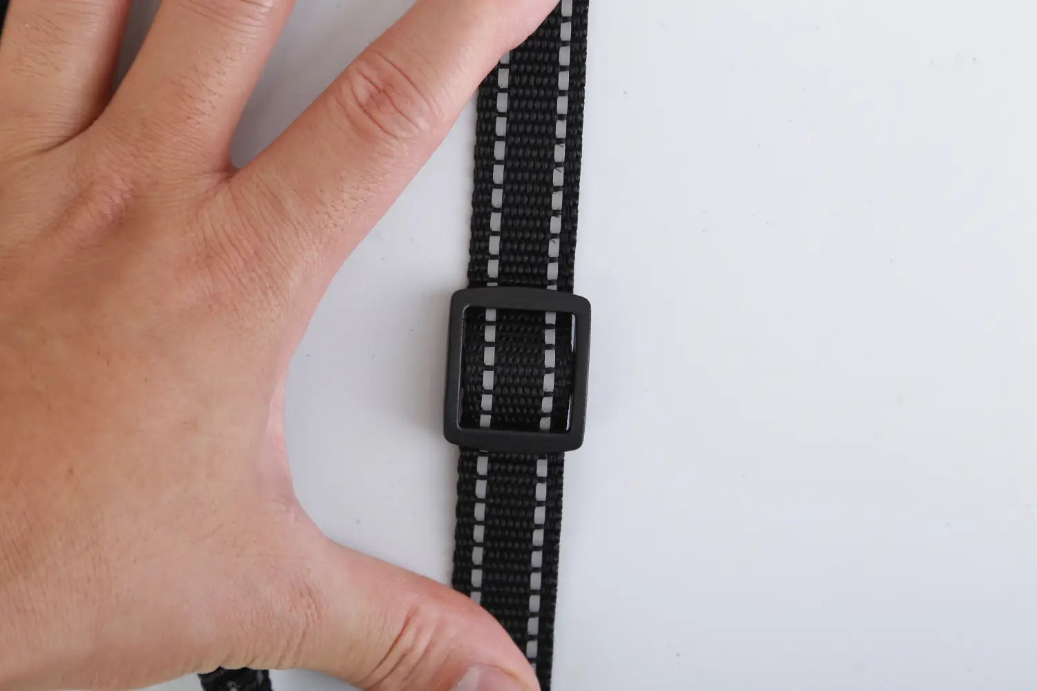 black webbing strap with reflective white stripes and a black plastic buckle on a dog training collar 3280ft waterproof shock system