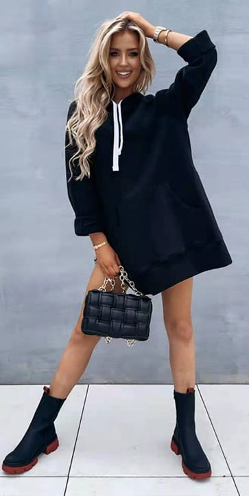 black quilted handbag with a chain strap paired with oversized mid length hooded sweatshirt dress with pockets.