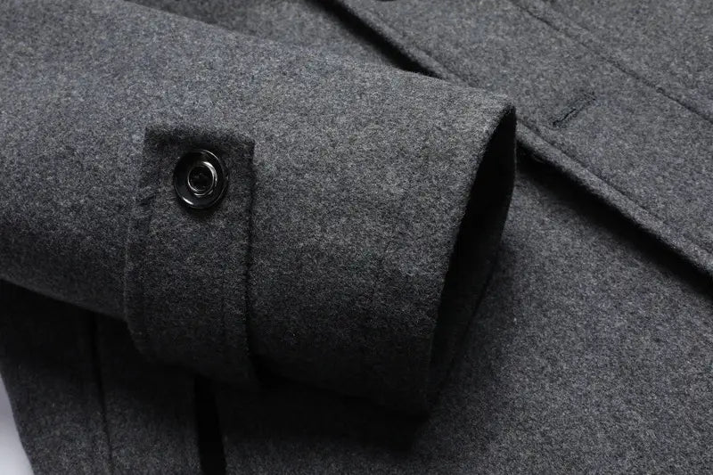 dark gray woolen coat cuff with a black button on a men wool winter overcoat quilted jacket.