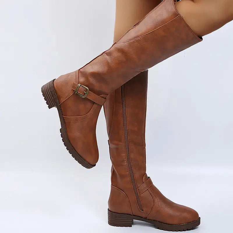 Brown leather knee high knight boots featuring a buckle strap and zipper closure.