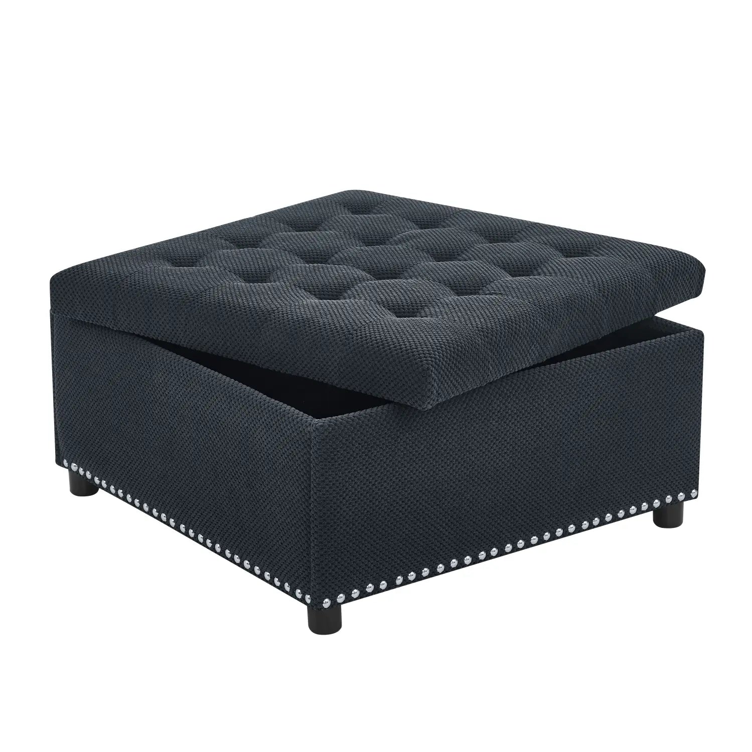 Black tufted storage ottoman in dark navy textured fabric with decorative silver nailhead trim along the base.