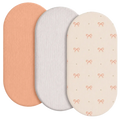 Set of three breathable fitted baby crib mattress covers in peach white and cream with textured pink bow patterns