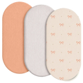 Set of three breathable fitted baby crib mattress covers in peach white and cream with textured pink bow patterns