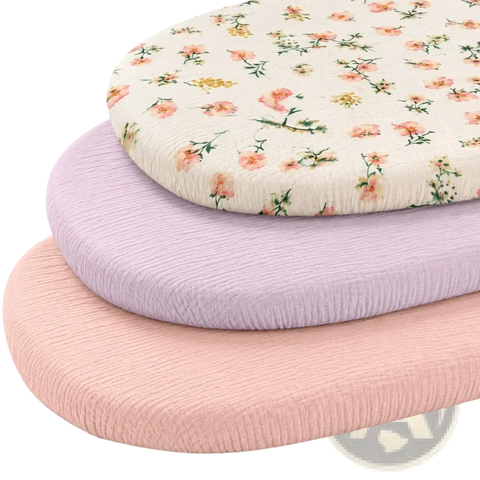 Stacked oval shaped baby crib mattress covers in soft pastel with delicate floral pattern and breathable cotton fabric