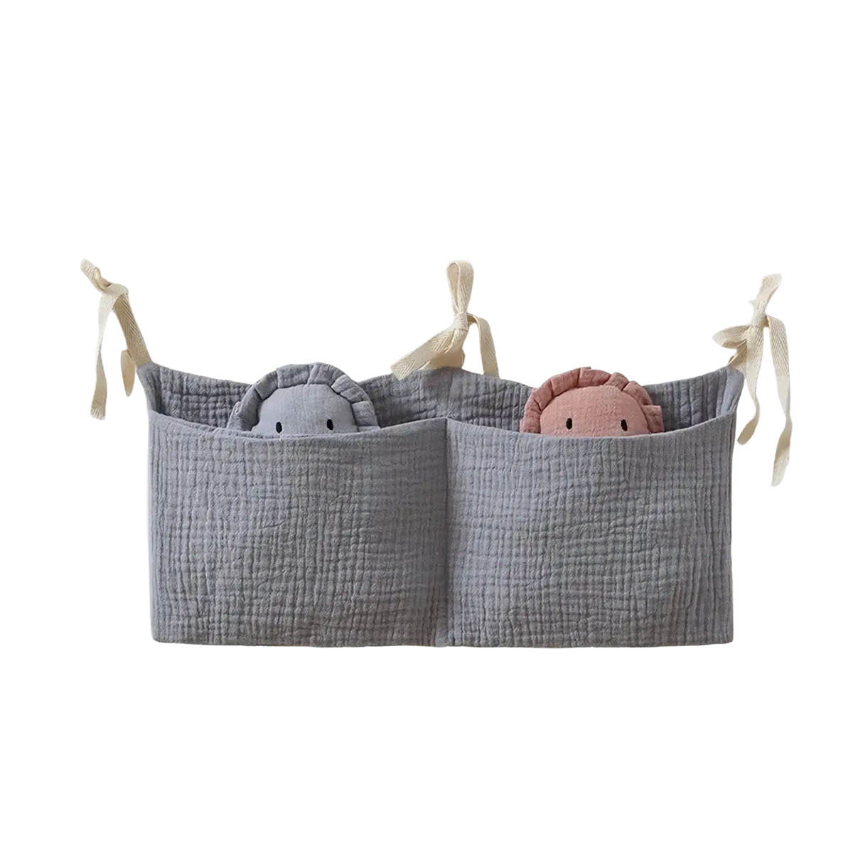 Gray cotton baby crib storage bag with two compartments holding plush toys for bedside organization