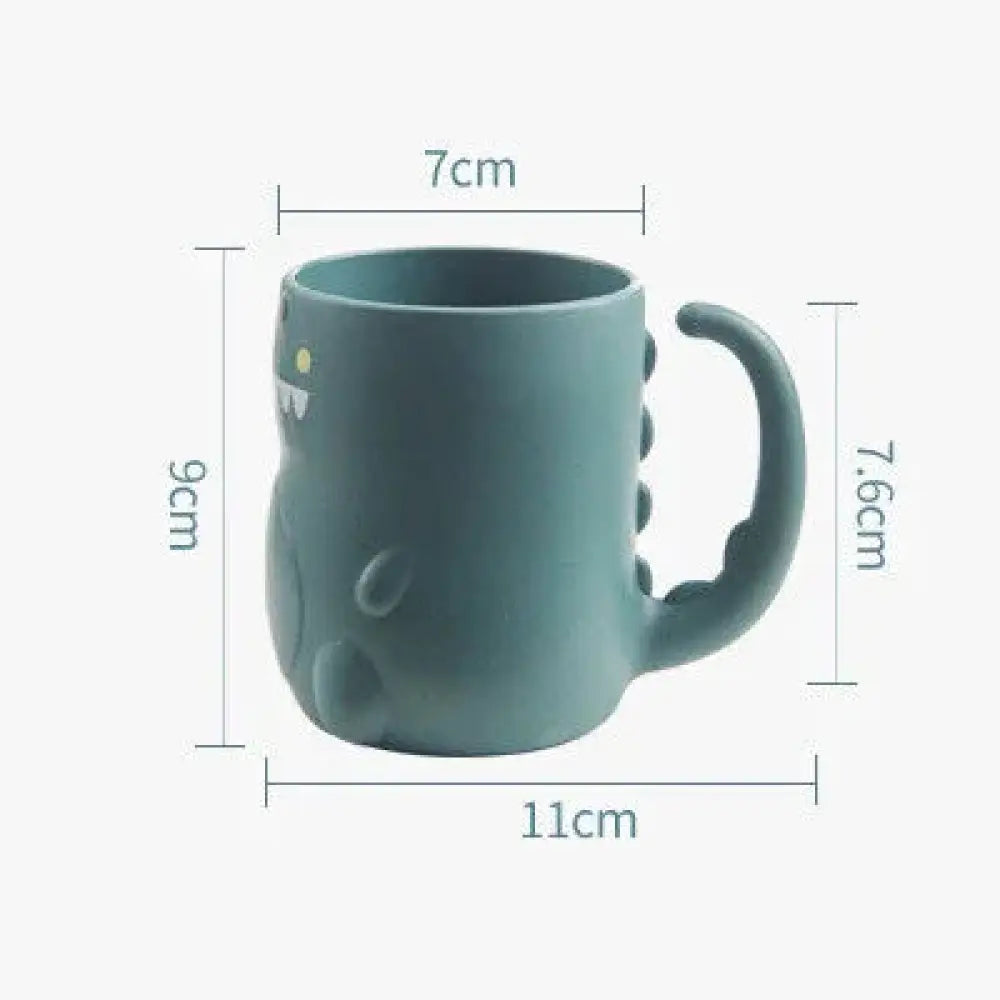 Teal ceramic toddler feeding mug shaped like a dinosaur with white teeth yellow eyes and spiky back details