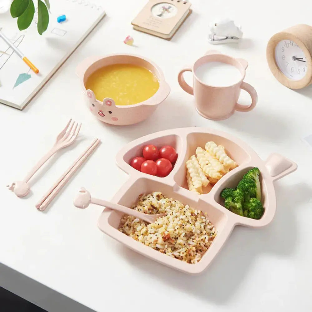 Pink silicone cat-shaped meal tray with three compartments holding rice broccoli and cherry tomatoes for toddler feeding