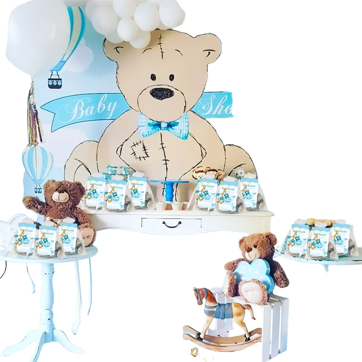 A plush brown teddy bear with a blue and white checkered bow tie holding a small gift bag for baby shower favors