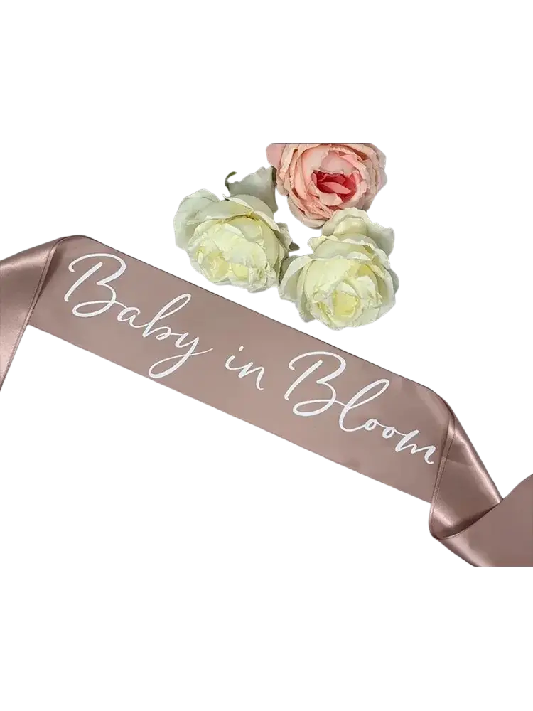 Rose-gold satin baby shower sash with baby in bloom white cursive script for mum to be maternity celebration