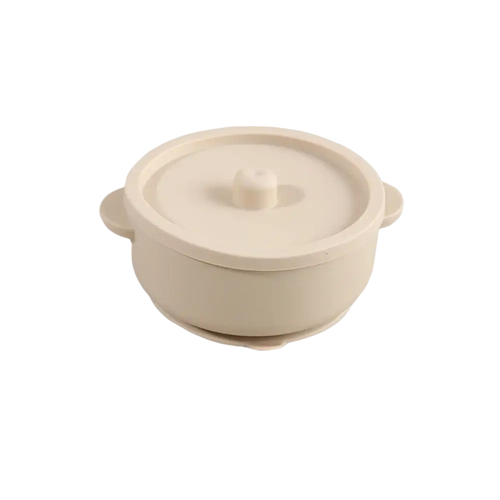 Cream-colored silicone baby training bowl with matching lid and handles for easy grip and portability in weaning dish design