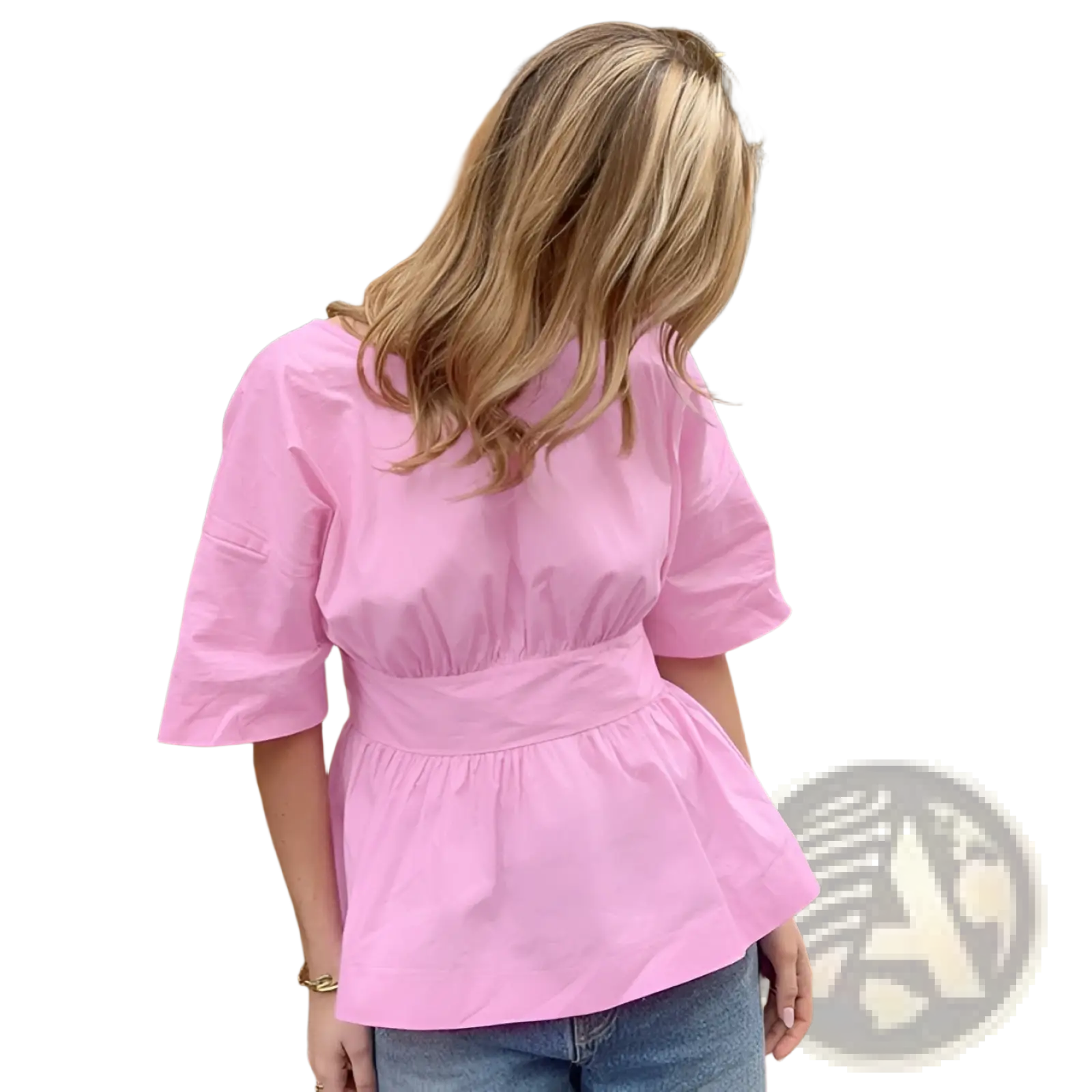 A soft pink cotton blouse with three-quarter sleeves and a peplum waist shown from the back with a tie closure