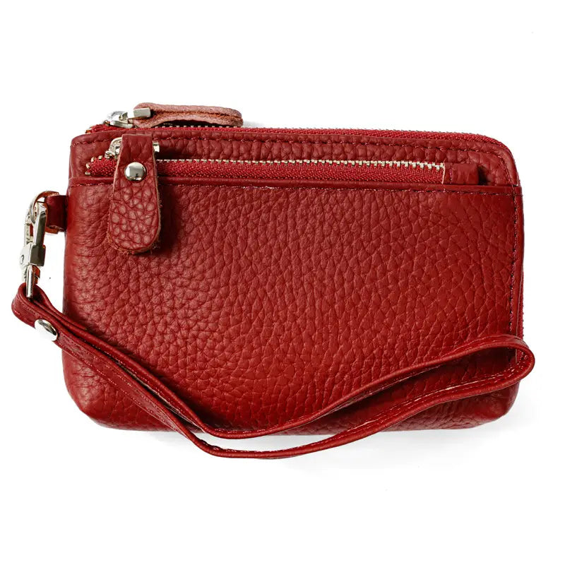 Premium textured red pebbled leather wristlet wallet with dual zippers and silver-toned metal clasp designed for secure and stylish carry.