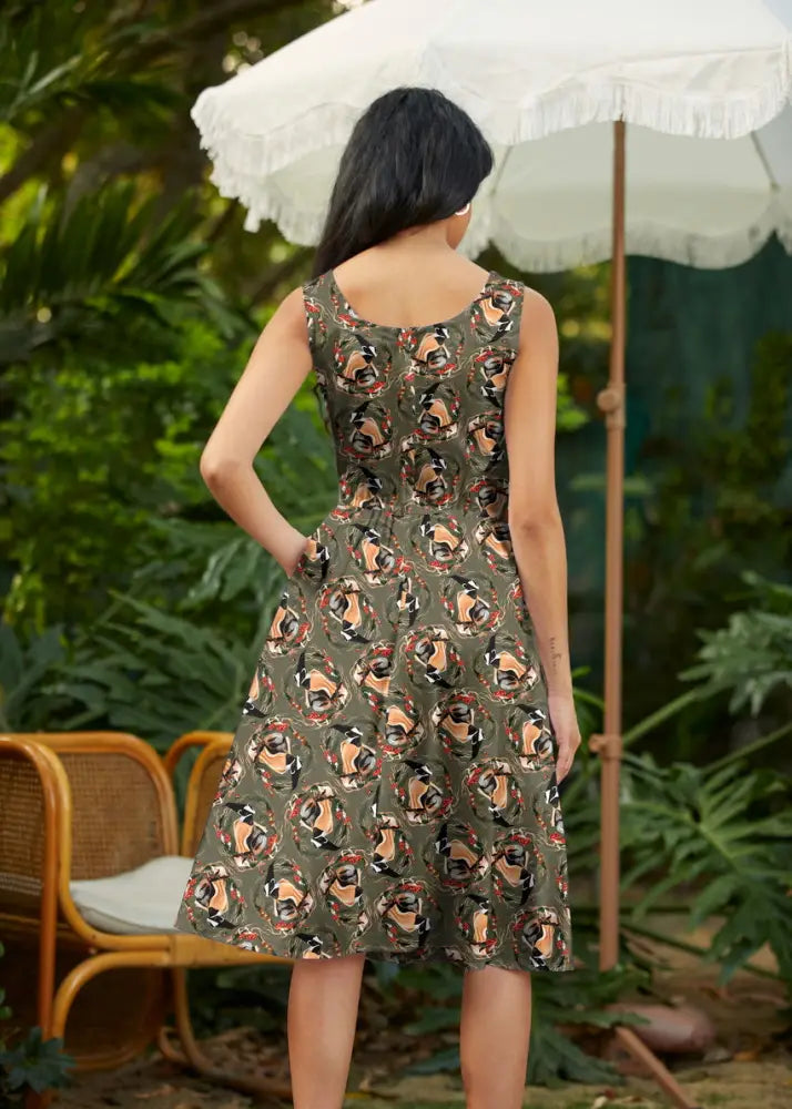 Vintage badger print olive cotton fit and flare sleeveless dress with a repeating circular pattern of stylized faces
