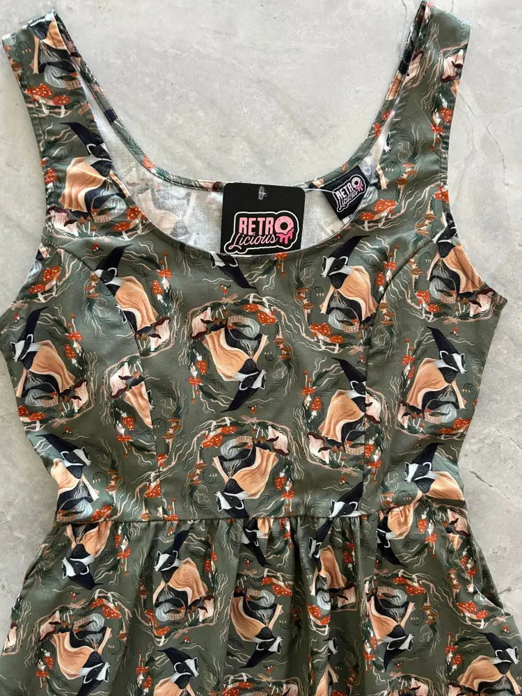 Olive green sleeveless vintage cotton fit and flare dress with playful retro badger print in peach and black