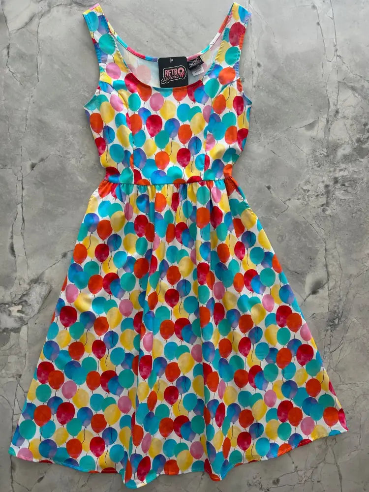 A vibrant sleeveless fit and flare dress with a multicolored watercolor balloon print on a white background