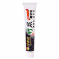 White tube of bamboo charcoal whitening toothpaste with black and green branding for deep stain removal