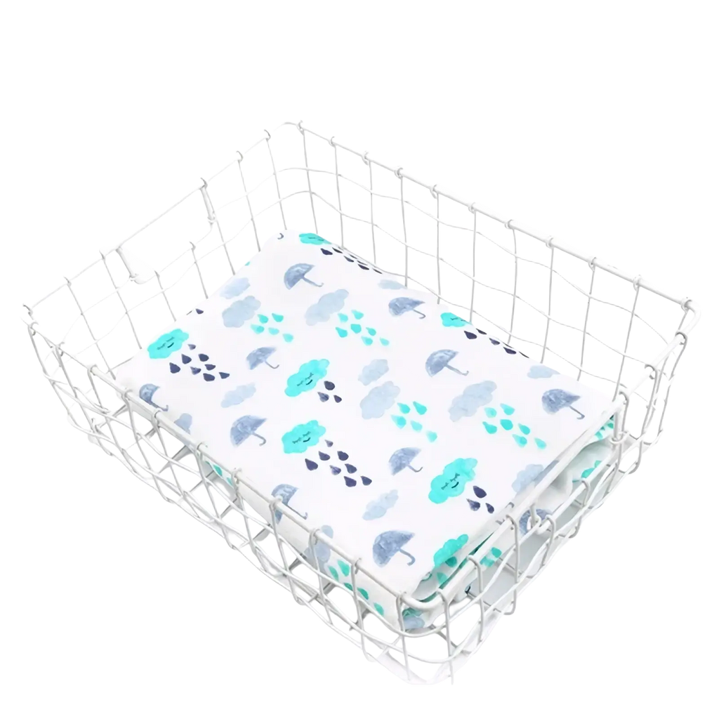 Bamboo cotton floral baby swaddle blanket with white fabric and teal gray umbrella raindrop cloud pattern in silver basket