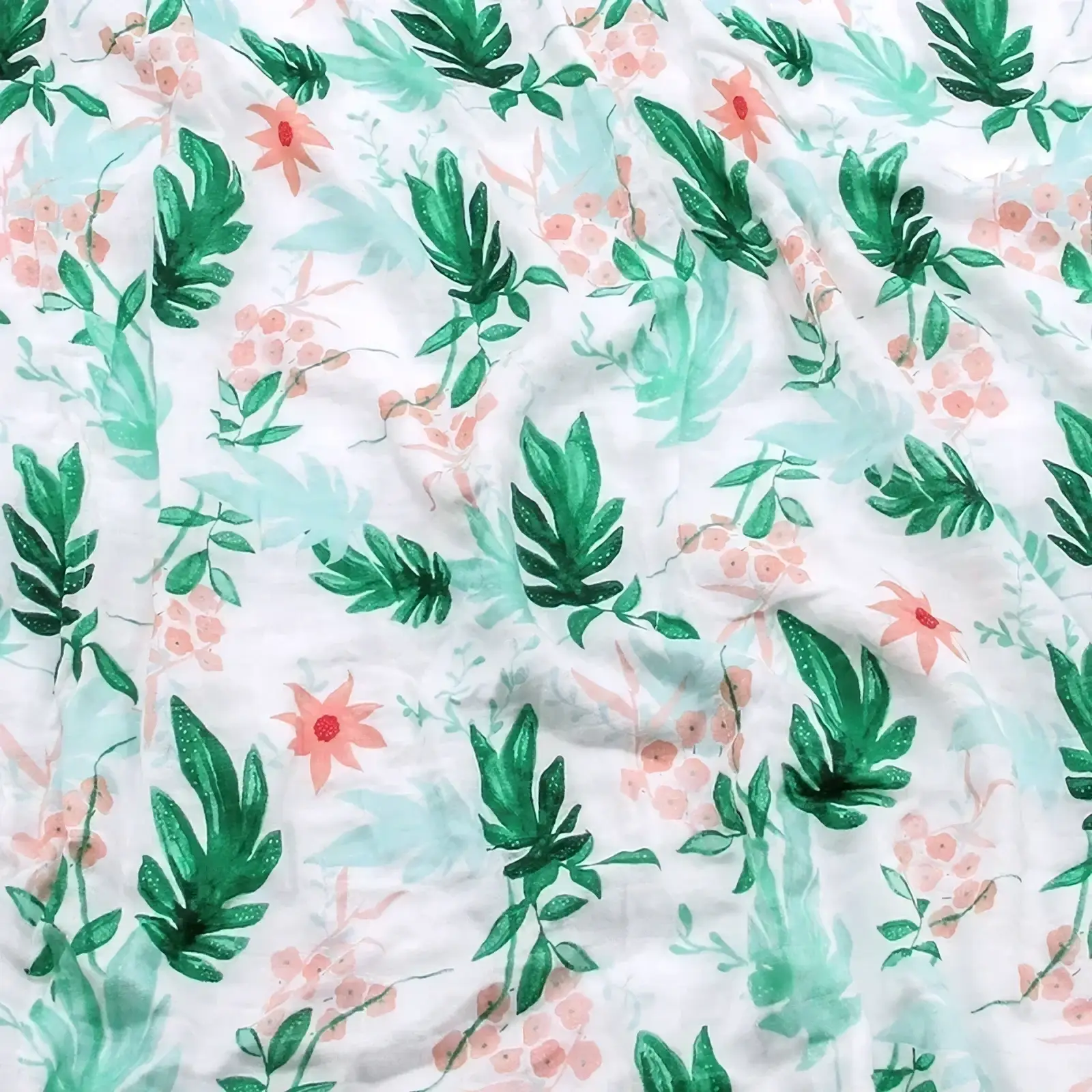 White bamboo cotton floral baby swaddle blanket with a watercolor-style print of green leaves and pink flowers