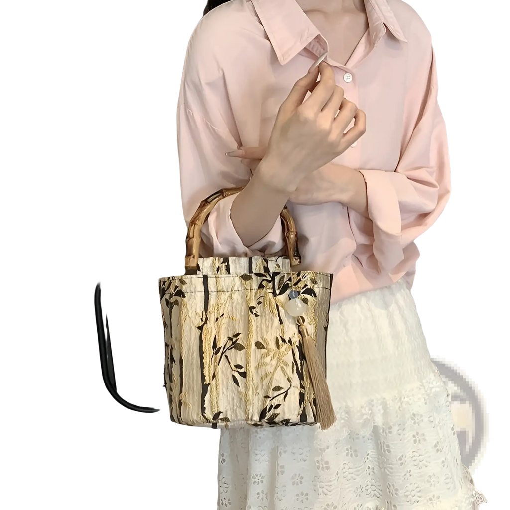 Beige and black patterned canvas bamboo handbag with tassel detail and bamboo handles for stylish carrying