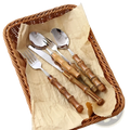 Set of four bamboo handle stainless steel cutlery pieces with polished silver blades and natural wood grain texture