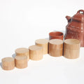 Set of handcrafted eco friendly bamboo cosmetic jars in natural wood finish with matching lids arranged by size