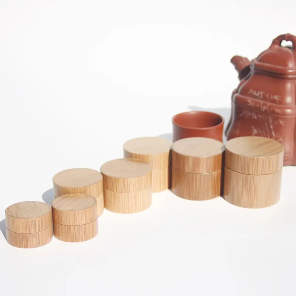 Set of handcrafted eco friendly bamboo cosmetic jars in natural wood finish with matching lids arranged by size