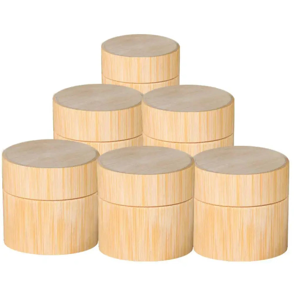 Light beige handcrafted eco friendly bamboo cosmetic jars with matching lids arranged in a pyramid stack